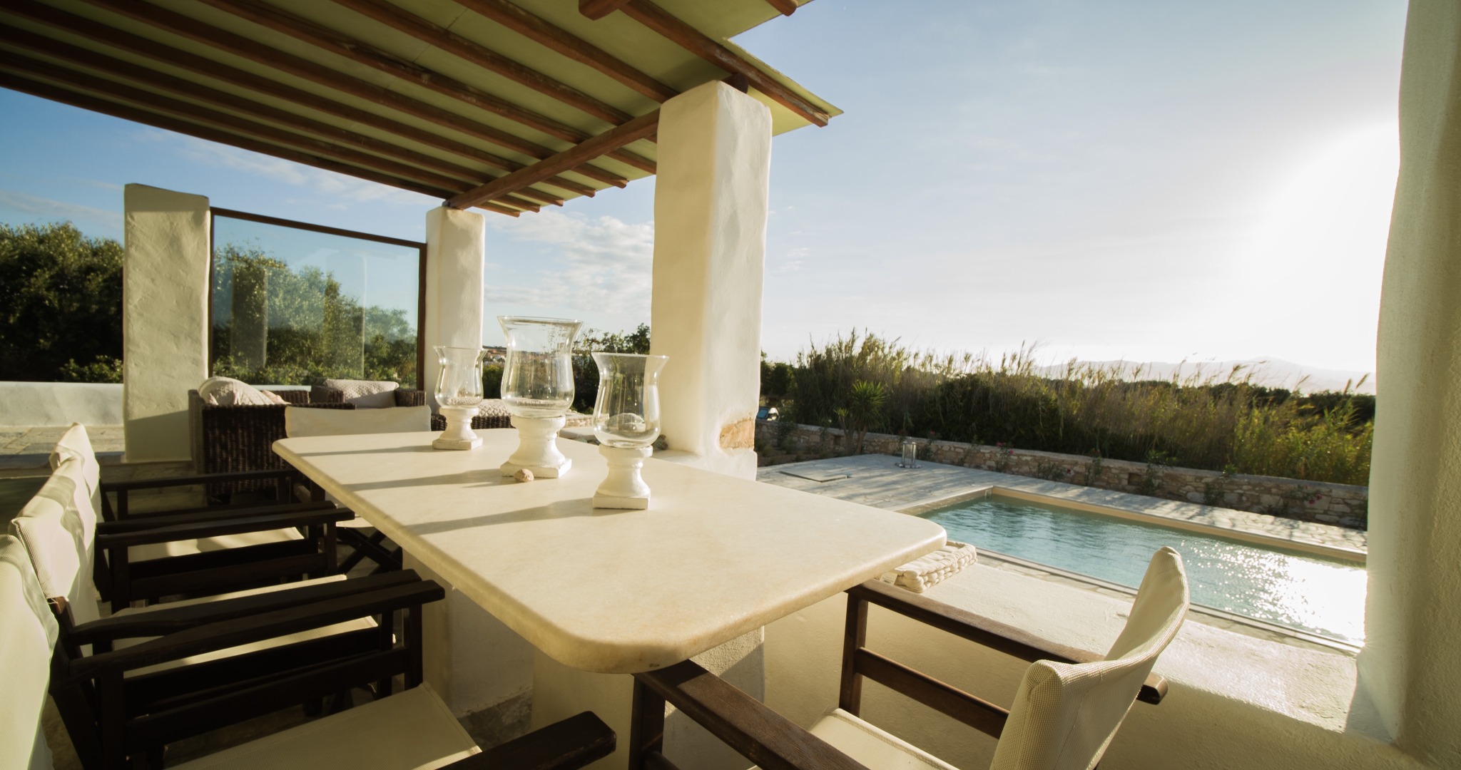 Lithos Private Estate outdoor dining area with pool view